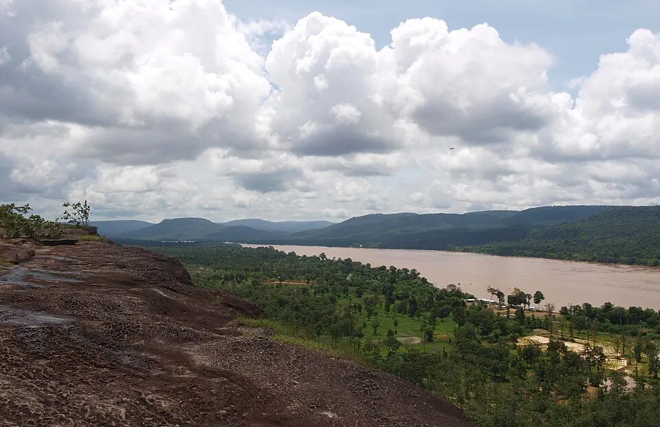View from a sandstone cliff across forest to the Mekong river and the hills of Laos